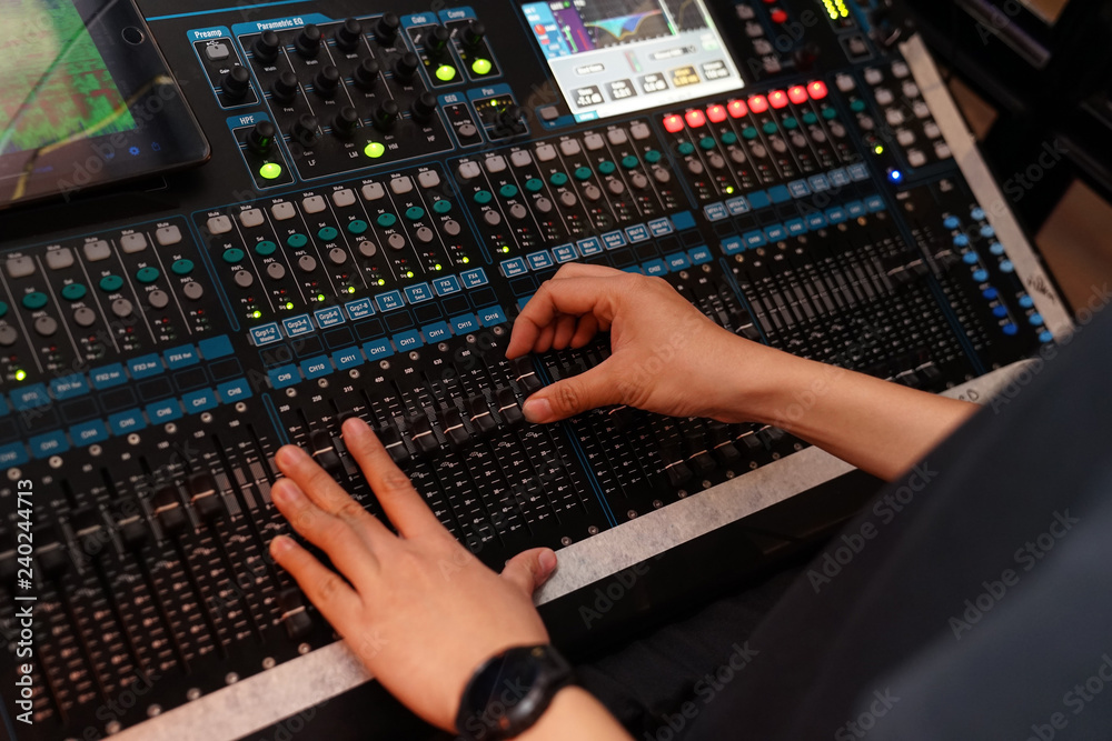 Dj controles sound controller and plays mixed edm music in the concert nightclub at a party. Dj controles sound controller and plays mixed edm music in the concert nightclub at a party.