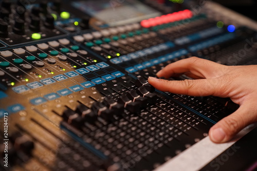 Dj controles sound controller and plays mixed edm music in the concert nightclub at a party.
