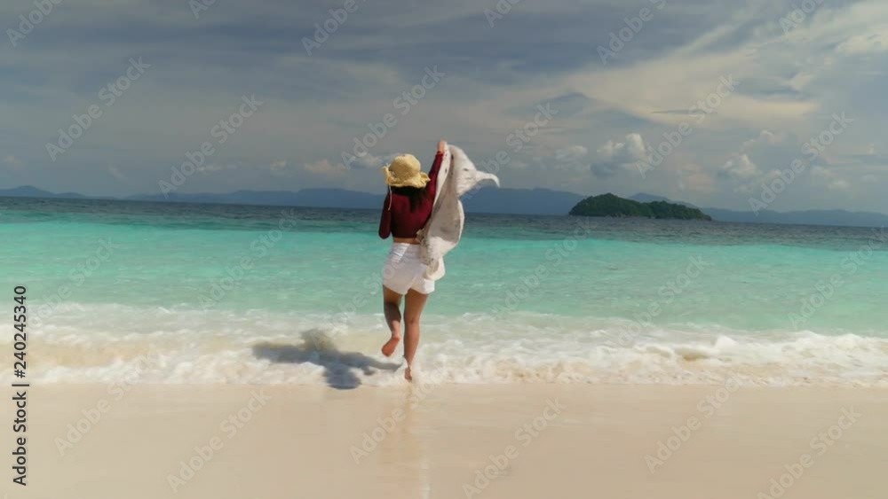 Beautiful young asian woman having fun running down the beach. Tropical vacation paradise island travel concept. Beautiful young asian woman having fun running down the beach. Tropical vacation paradise island travel concept.