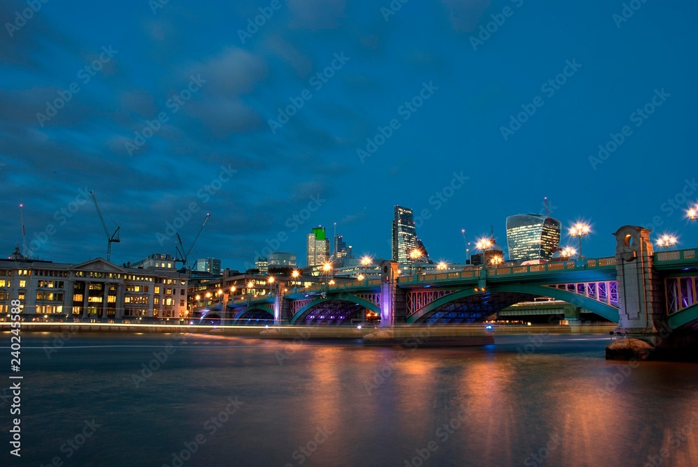 Southwark Bridge from the south bank of the River Thames in the early evening.