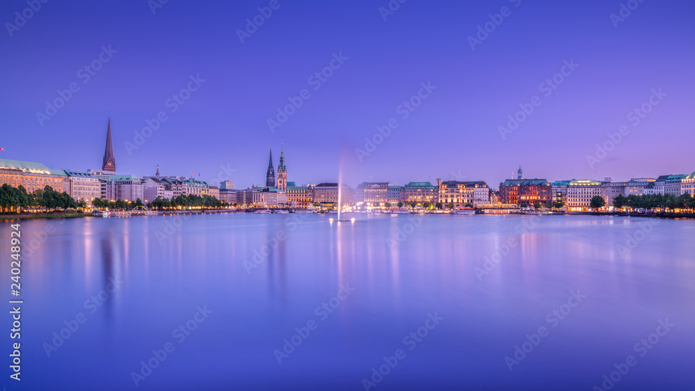 The Inner Alster Lake (German: Binnenalster) in Hamburg, Germany. Evening view of the inner city at dusk with the fountain reflecting in the water.