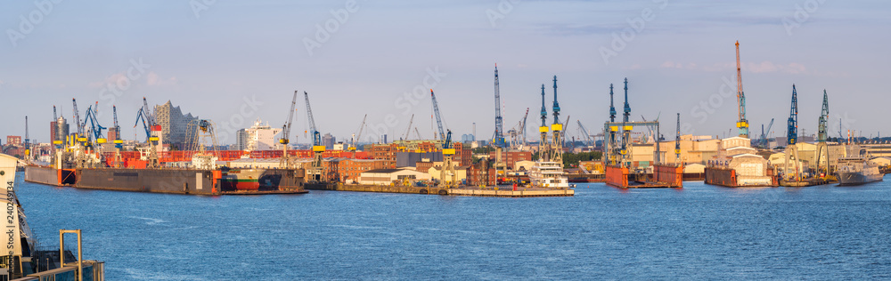 Aerial view of Hamburg Harbor, Germany, with docks and cranes in the evening sun.