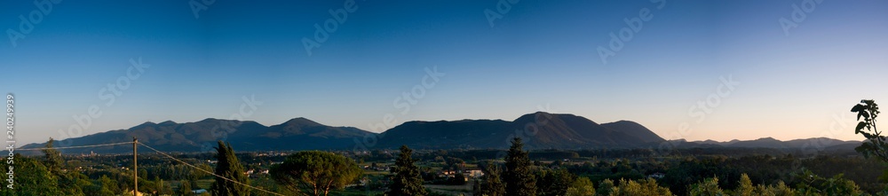 A panorama of valley in Tuscany at sunset with mountains in the background, Tuscany, Italy