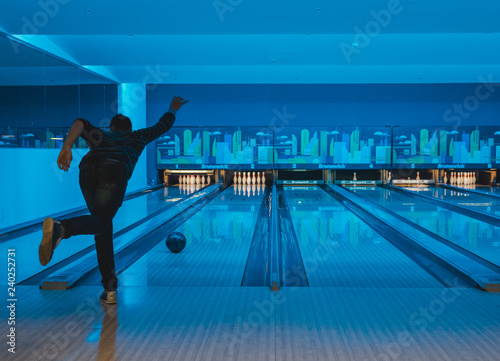 young man throwing bowling ball