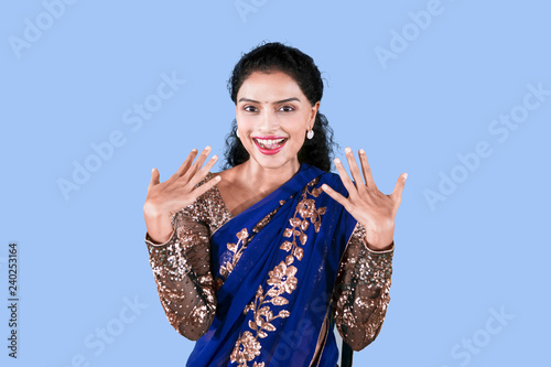 Excited woman wears a blue saree dress on studio