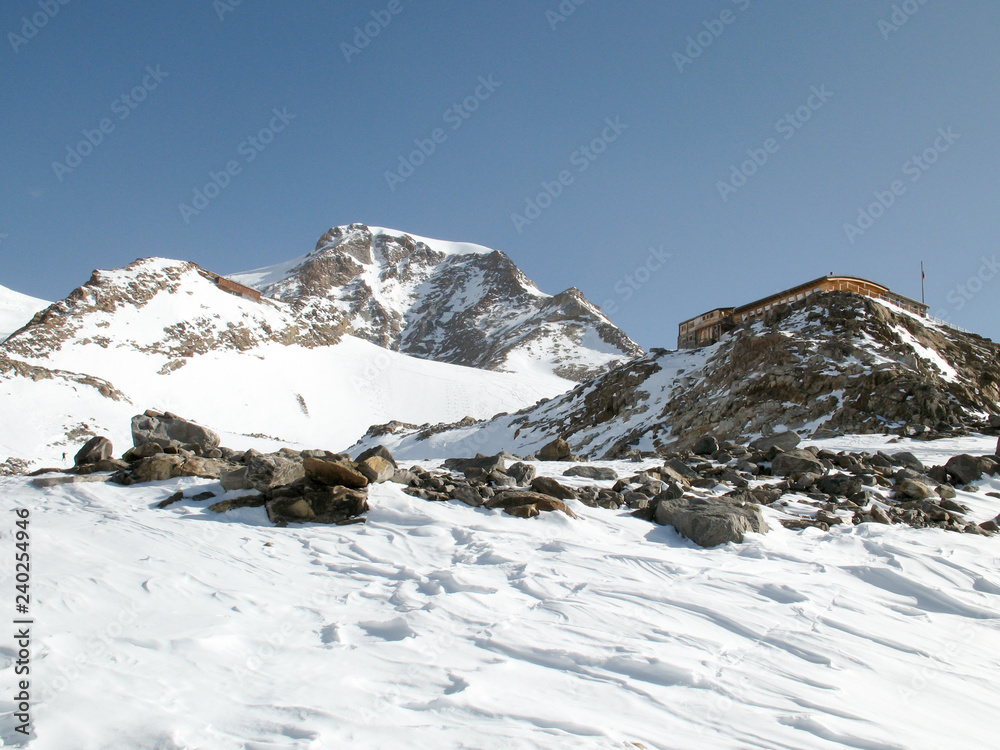 winter mountain landscape in the Monte Rosa range in Switzerland with the Mantova mountain hut on ist rocky promontory