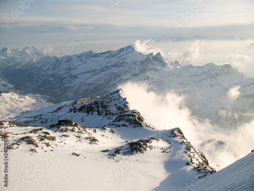 winter mountain landscape in the Monte Rosa range in Switzerland with the Mantova mountain hut on ist rocky promontory photo