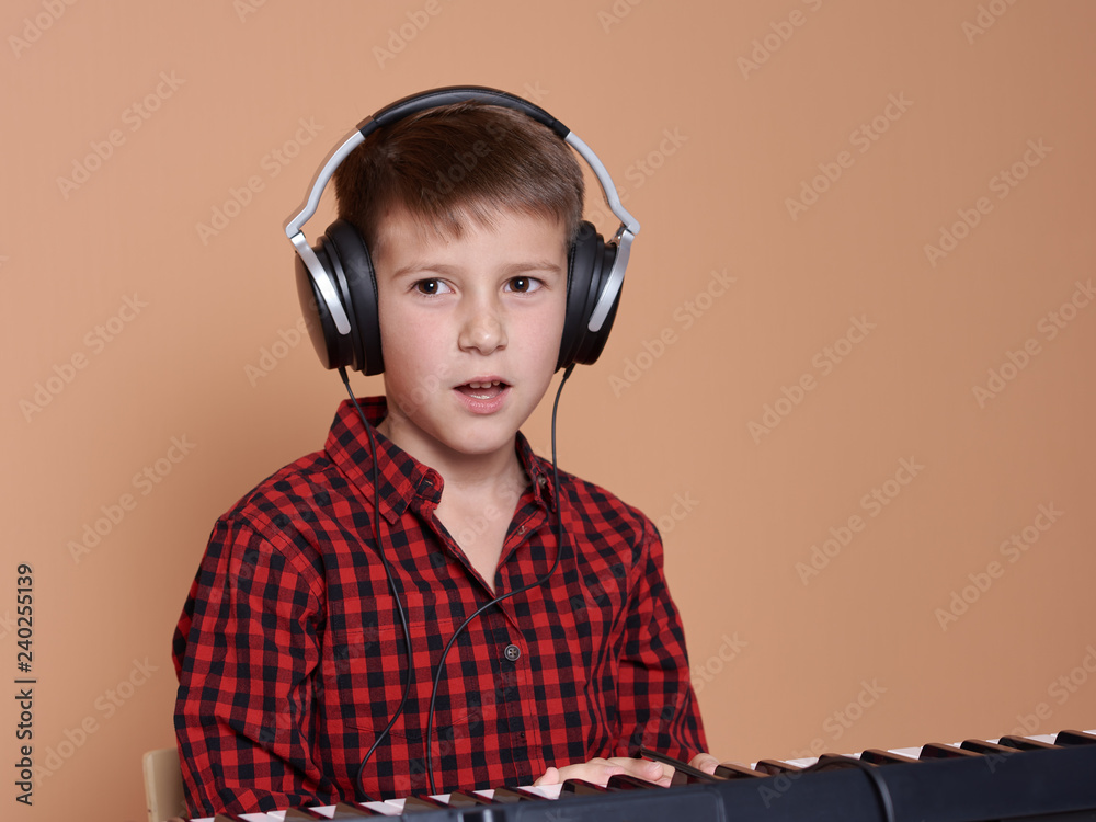 The portrait of a good-looking European boy on a peach background. He ...