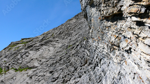 bizarre banded rock formation in mountain landscape with blue sky