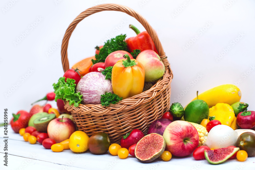 Fresh vegetables and fruit in basket isolated on white.