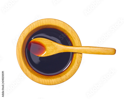 Soy sauce in wooden bowl isolated on white background.