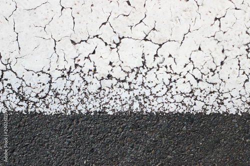 Asphalt pavement sign marking crosswalk white paint wet old surface texture detail