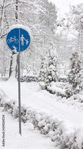 Cyclist pedestrian road sign Located in a snow covered park