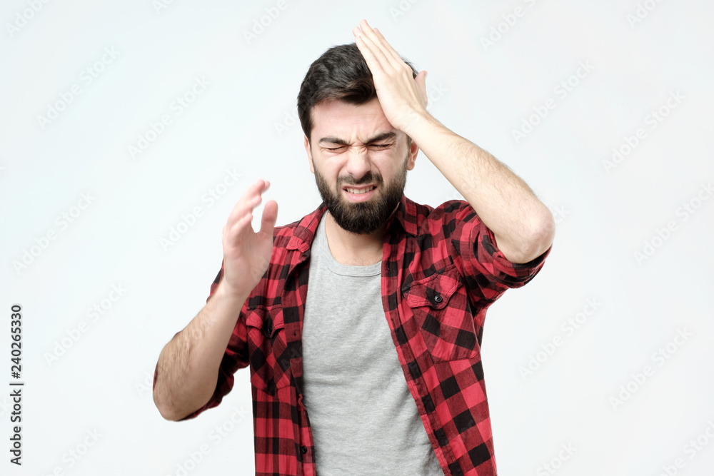 Troubled worried and nervous concerned handsome man pressing hands to head and clenching teeth panicking being in perplexed situation, forgetting important thing Troubled worried and nervous concerned handsome man pressing hands to head and clenching teeth panicking being in perplexed situation, forgetting important thing