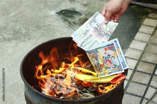 Burning the silver and gold fake money paper for chineses dead people ancestors. Joss paper money burning metal bugket dead in chinese new year.
