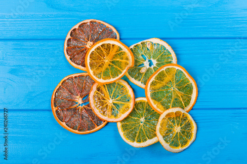 Dried orange and lemon slices over blue background. Top view.