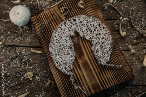 folk art of the Northern peoples of nails, white thread and boards as a background photo