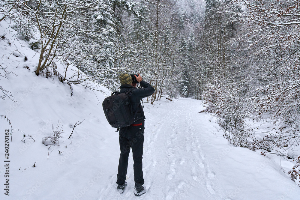 Tourist with camera in the winter landscape