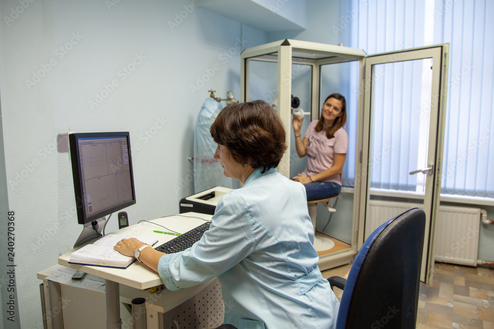 the girl is sitting in a booth for spirometry with a clothespin on her