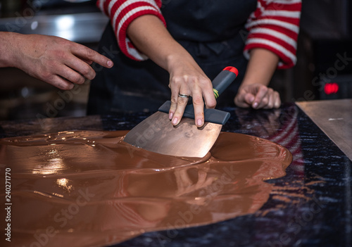 Фотография Tempering melted chocolate on table