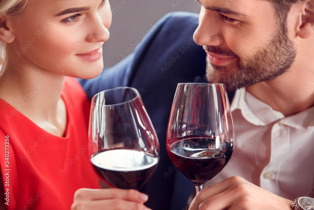 Young couple on date in restaurant sitting drinking wine looking at each other passionate Young couple on date in restaurant sitting drinking wine looking at each other passionate