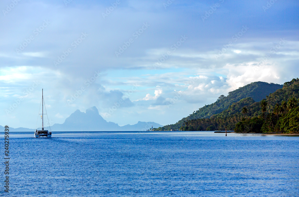 Lonely catamaran heading for the Bora-Bora island in the Leeward group of the Society Islands of French Polynesia.