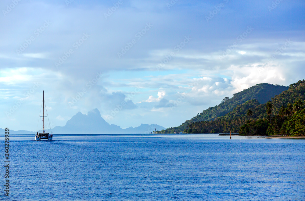 Lonely catamaran heading for the Bora-Bora island in the Leeward group of the Society Islands of French Polynesia. Lonely catamaran heading for the Bora-Bora island in the Leeward group of the Society Islands of French Polynesia.