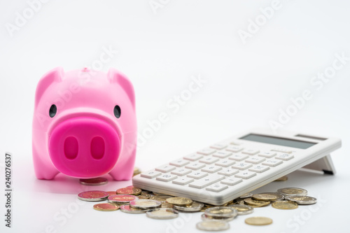 House model, piggy bank, and calculator on coins stacks. Concept for money saving for housing, property ladder, mortgage and real estate investment . photo