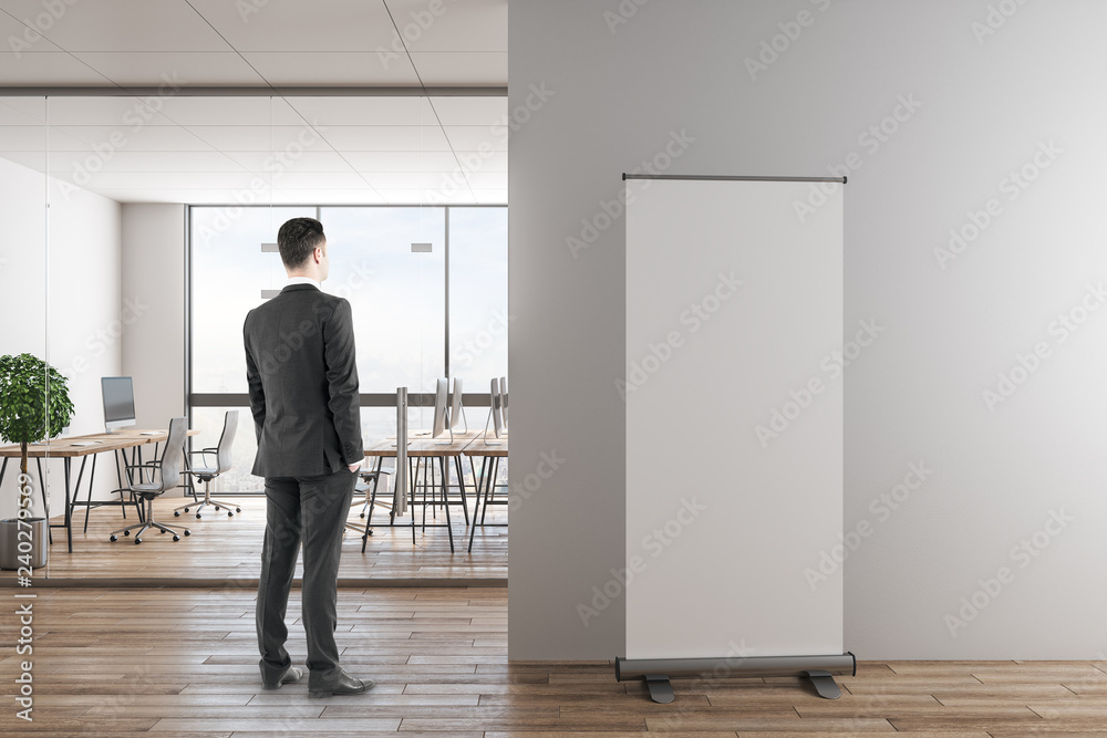 Fototapeta premium Businessman in modern office with banner