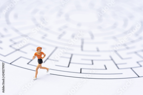Miniature people, runner at the way out of the labyrinth. Business concept, finding solution, strategic, and business opportunity.