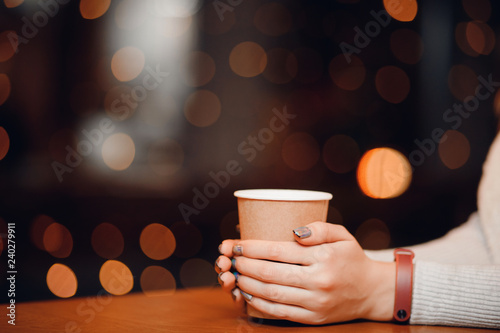 Cup hot tea or coffee in hands of woman with beautiful unusual nail design, manicure, and fitness bracelet.