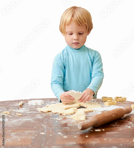 child makes cookies from dough on the table