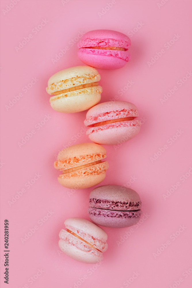 Obraz premium Top view of colorful macaron or macaroon on pink background.