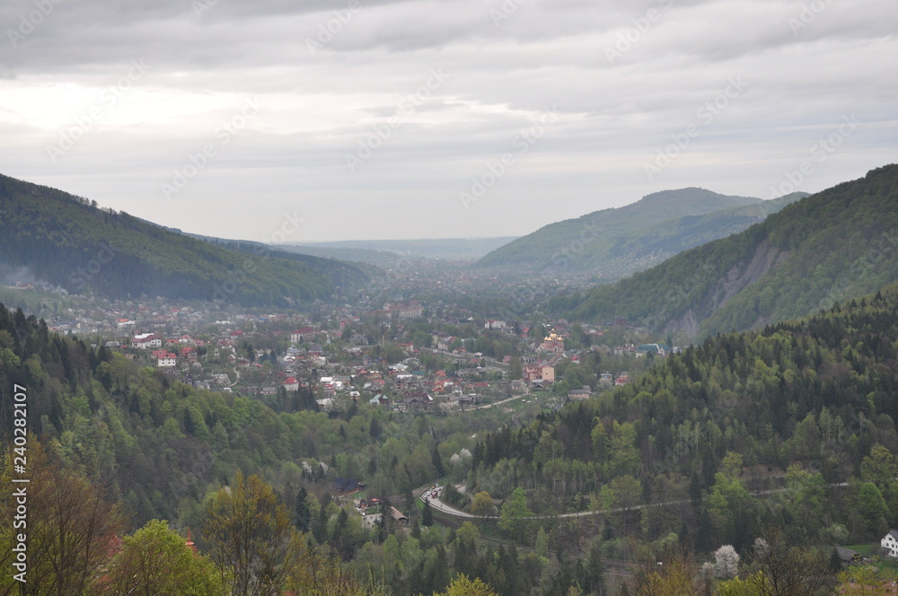 Panoramic view of the mountains. Ukrainian Carpathians view of the mountains and the city between them. Clouds over a mountain village in the Carpathians.