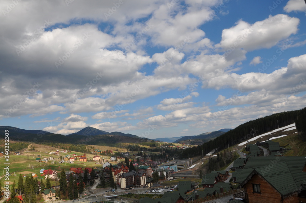 Panoramic view of the ski resort Bukovel. Ukrainian Carpathians view of the mountains and the city between them. Clouds over a mountain village in the Carpathians.