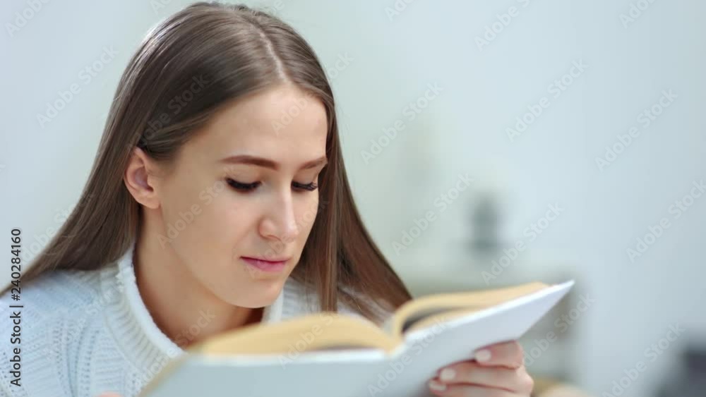 Close-up face of enthusiastic young woman reading interesting book Close-up face of enthusiastic young woman reading interesting book