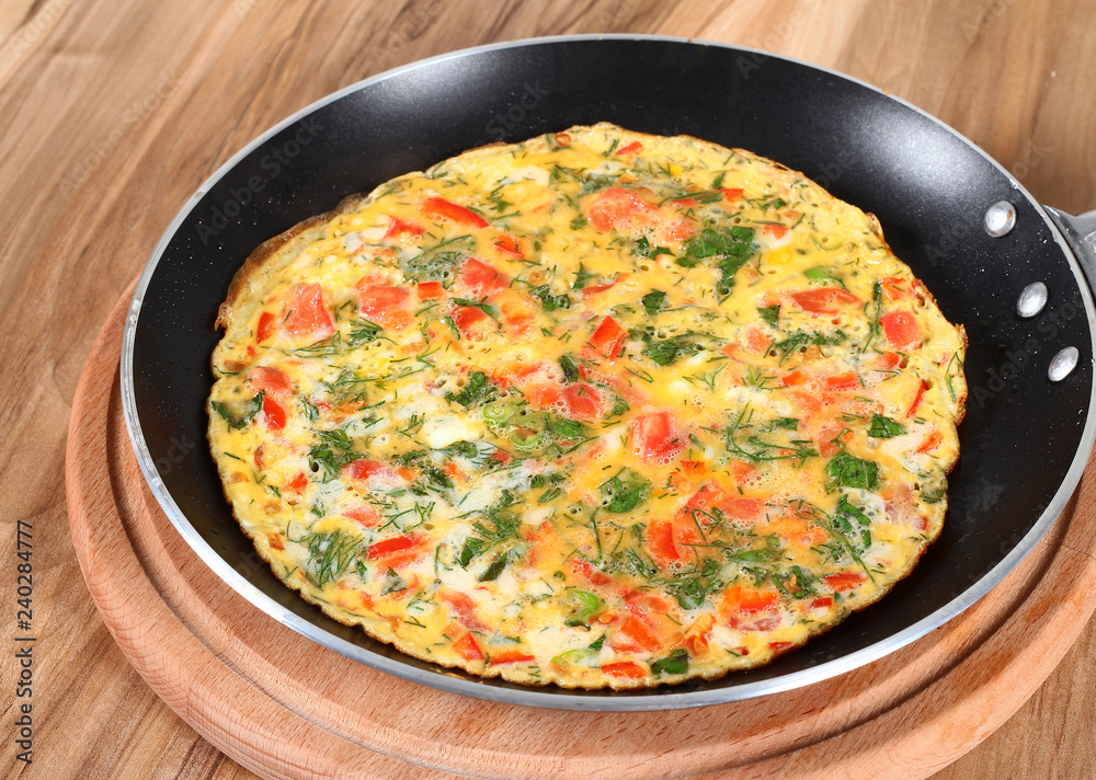 Omelette with tomatoes, parsley and cheese in pan Omelette with tomatoes, parsley and cheese in pan