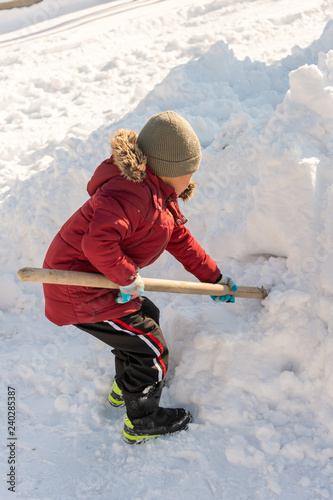 boy cleans snow in the yard
