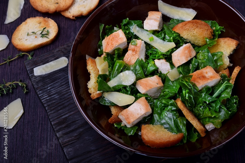 Salad with chicken, Parmesan cheese, crispy croutons and kale in a bowl
