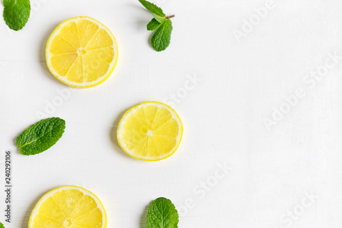 Fresh lemon slices on a white background. Background with lemon and mint. Beautiful photo with citrus. Vitamin C. Lemon and Fresh Mint Pattern