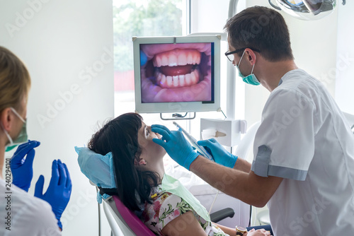 Fotografie Dentist checking patient's teeth with intraoral camera
