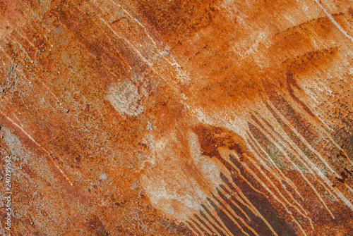 painted iron surface with a large rusty and metal corrosion, old background with peeling and cracking paint as background, orange texture