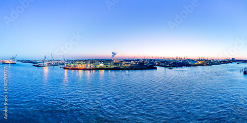 Aerial view of Hamburg Harbor  Germany   at dusk. The Port of Hamburg  Hamburger Hafen  is a sea port on the river Elbe. It is Germany s largest port and the second-busiest port in Europe.