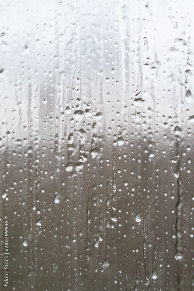 The frozen drops on the patterned frosty winter window