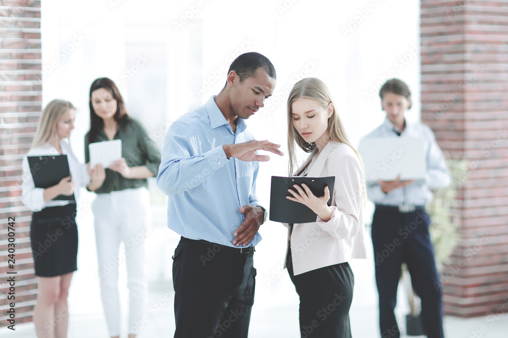 employees discussing business document standing in the office employees discussing business document standing in the office