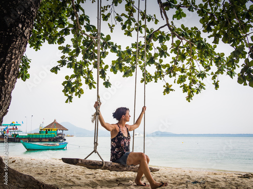 Caucasian woman sitting on a wooden swing