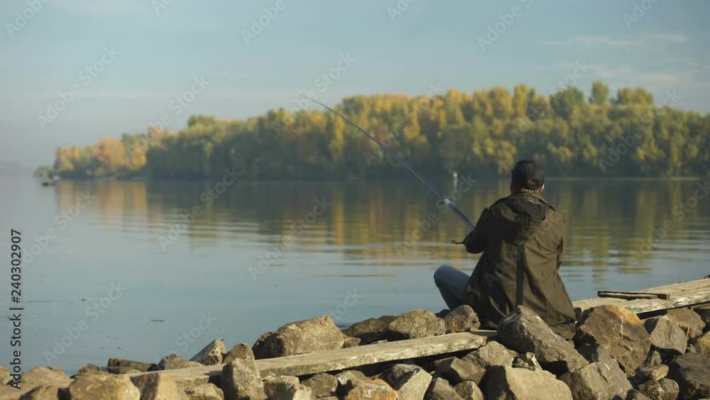Single fisherman casting fishing rod, waiting for fish, beautiful nature, hobby Single fisherman casting fishing rod, waiting for fish, beautiful nature, hobby