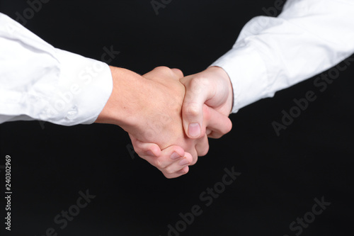 close up. handshake business partners. isolated on black background