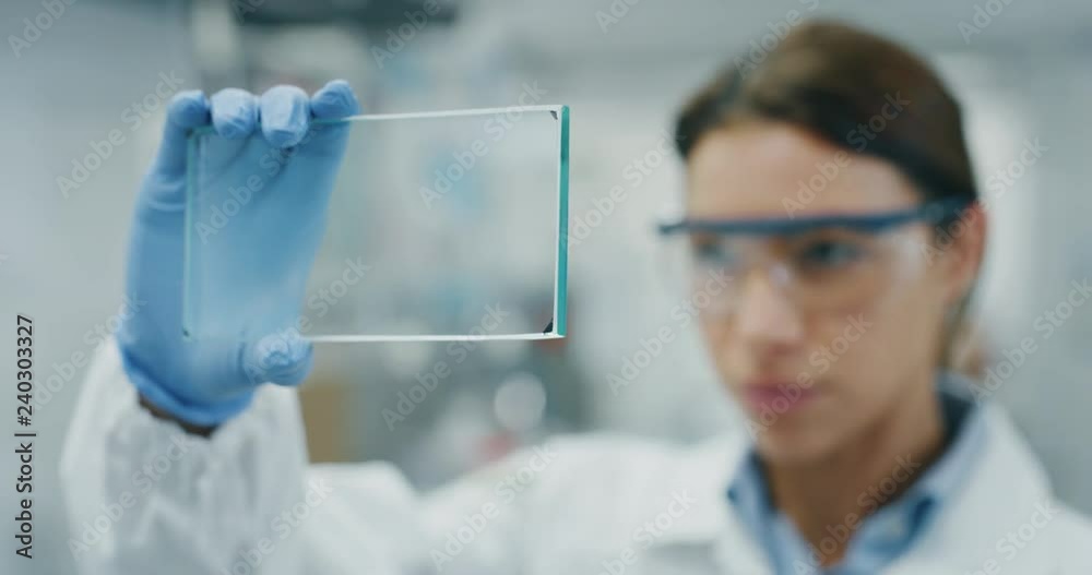Portrait of futuristic researcher using the augmented reality screen with hologram graphics for viewing results of his research in laboratory. Shot in 8K. Concept of futuristic medicine and science