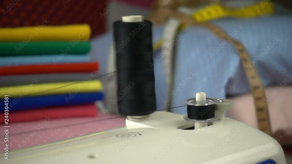 Thread is unwound from the reel during sewing to other coil in slow motion. Sewing preparation. Thread is unwound from the reel during sewing to other coil in slow motion. Sewing preparation.